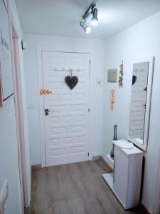 a white door with a heart hanging on it at Apartamento El Príncipe in Peñíscola