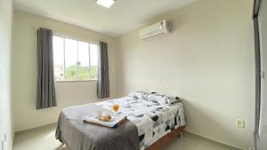 een slaapkamer met een bed met een dienblad met eten erop bij Aconchegante Apartamento na Praia de Bombas com ótima localização. in Bombinhas