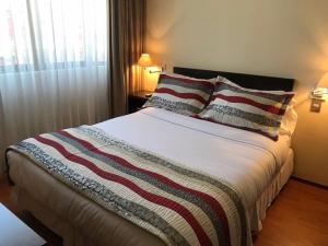 um quarto com uma cama grande e 2 almofadas em Hotel Capelli Express em Talca