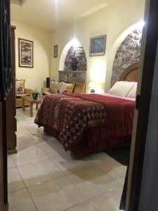 a bedroom with a bed and a living room at La Capilla Apartment In ExHacienda La Escalera in Guanajuato