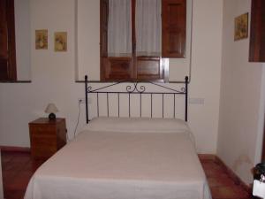 a bedroom with a bed and a dresser and a window at El Zaguan in Granada