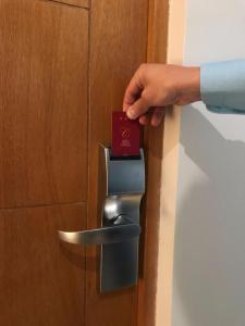 a person is unlocking a door with a card at Hotel Capelli Express in Talca