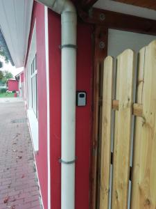 una puerta roja con un poste blanco al lado de un edificio en Uckermark "Ferienwohnung Sommerfugl ", en Passow