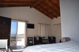 1 dormitorio con 1 cama y balcón en Viñas del Castillo, en Ensenada