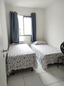 um quarto com duas camas e uma janela em Apartamento Condominio Caminho dos Ventos em Aracaju