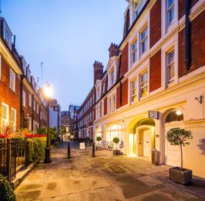 una strada vuota in una città con edifici di Native Mayfair a Londra