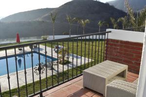 a balcony with a fence and a swimming pool at Viñas del Castillo in Ensenada