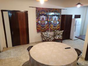 une chambre avec une table, des chaises et un rideau dans l'établissement Casa de Praia Picinguaba, à Ubatuba