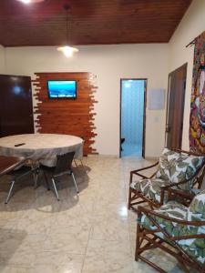 un salon avec une table et deux chaises dans l'établissement Casa de Praia Picinguaba, à Ubatuba