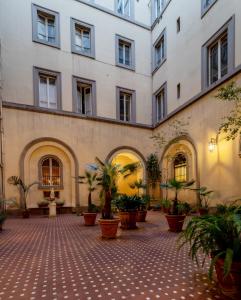 un grande edificio con cortile con piante in vaso di I LOVE ROMA Guest House a Roma