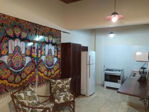 a kitchen with a painting on the wall at Casa de Praia Picinguaba in Ubatuba +5 photos