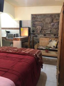 a bedroom with a bed and a desk with a computer at La Capelina Apartment in ExHacienda la Escalera in Guanajuato