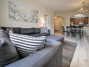 ein Wohnzimmer mit einem Sofa und einer Küche in der Unterkunft 3Br 2Bath Condo Balcony 5min Conv Center 1388ft in Orlando