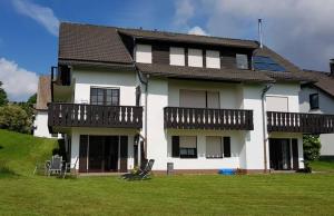 a large white house with a lawn in front of it at Appartement Neuastenberg in Winterberg