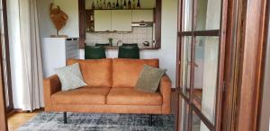 un sofá marrón en una sala de estar con cocina en Appartement Neuastenberg, en Winterberg
