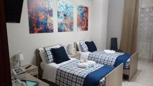 a bedroom with two beds and a painting on the wall at B&B Fratelli Baglione in Sora