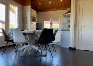 une cuisine avec une table et des chaises. dans l'établissement Chaletparc Krabbenkreek Zeeland - Chalet 214, à Sint-Annaland