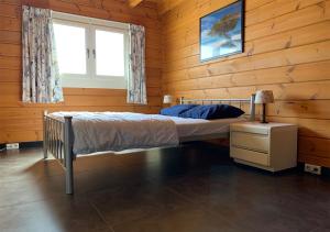 - une chambre avec un lit dans une cabane en bois dans l'établissement Chaletparc Krabbenkreek Zeeland - Chalet 214, à Sint-Annaland