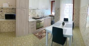 a kitchen with a white counter and a table with chairs at B&B Fratelli Baglione in Sora