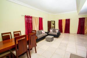 sala de estar con mesa y cortinas rojas en Villas Garcia, en Las Terrenas