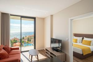 ein Hotelzimmer mit einem Bett und einem großen Fenster in der Unterkunft Monumental Plaza by Petit Hotels in Funchal