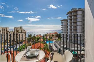 balcón con mesa, sillas y vistas al océano en Monumental Plaza by Petit Hotels, en Funchal