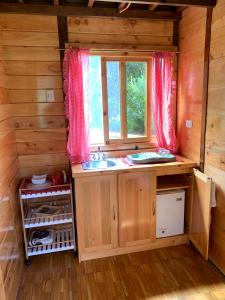 a kitchen with a sink and a window in a cabin at Charming cabin surrounded by nature in El Escudero