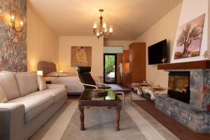 a living room with a couch and a fireplace at VORAS 180° VIEW in Palaios Agios Athanasios