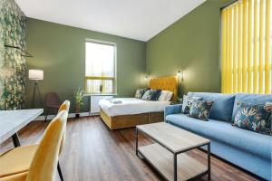 a living room with a blue couch and a bed at Queen Street Apartments by Sasco in Blackpool