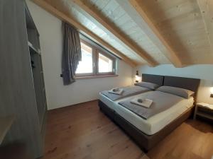een slaapkamer met een groot bed op zolder bij Appartamenti Florin in Livigno