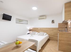 - une chambre avec un lit, une table et un lavabo dans l'établissement Apartments & Rooms Buble, à Trogir