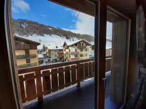 een uitzicht vanuit het raam van een balkon met sneeuw op de grond bij Appartamenti Florin in Livigno