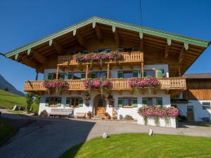uma casa com uma varanda com flores em Ramslerhof - Chiemgau Karte em Inzell