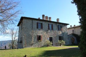 an old stone building on a grassy field at Villa Auditorium in Fortunago