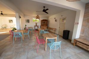 ein Zimmer mit Tischen, Stühlen und einem Sofa in der Unterkunft Lazy Parrot Inn & Mini Resort in Rincon