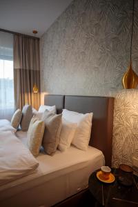 Cette chambre comprend un lit avec des oreillers blancs. dans l'établissement Mokka Best Apartments, à Miskolc