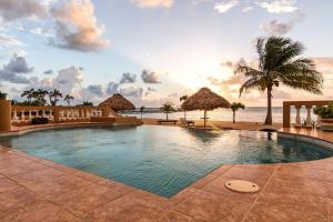 a swimming pool with the beach in the background at Hol Chan Reef Resort & Villas in San Pedro +52 photos