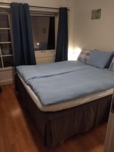 a bed in a room with a blue blanket on it at Modern apartment in Svolvær
