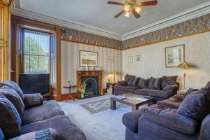a living room with two couches and a fireplace at The Old Bank House Self Catering Apartment Dornoch in Dornoch