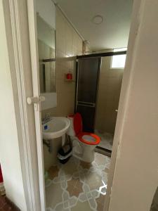 a bathroom with a red toilet and a sink at Hostería tropical la florida in La Florida