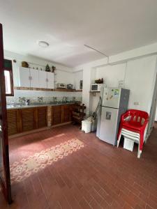 een keuken met een rode stoel en een koelkast bij Hostería tropical la florida in La Florida
