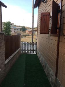 a backyard with a green lawn and a fence at Cabañas Montes Universales in Orihuela del Tremedal