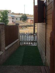 a yard with a fence and a green lawn at Cabañas Montes Universales in Orihuela del Tremedal