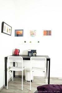 een zwart-witte keukentafel met twee witte stoelen bij 1 chambre 14 m2 + SDB + cuisine + Terrasse en jardin pour 2 voyageurs in Trévignin