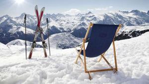 a chair and skis in the snow on a mountain at 1 chambre 14 m2 + SDB + cuisine + Terrasse en jardin pour 2 voyageurs in Trévignin