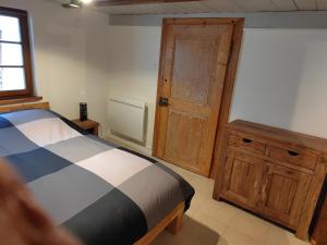 1 dormitorio con 1 cama y puerta de madera en Petite maison alsacienne, en Entzheim