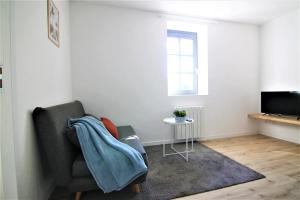 ein Wohnzimmer mit einem Sofa und einem TV in der Unterkunft T2 Charmant - Segré centre ville - 003 in Segré