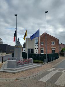 un monumento con banderas frente a un edificio en Vakantiewoning 'De Vlaamse Aap', en Dilsen-Stokkem