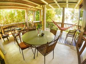 eine Terrasse mit einem Tisch und Stühlen auf einer Veranda in der Unterkunft Casa Janaina in Ilhabela