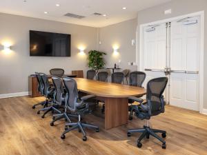 a conference room with a wooden table and chairs at 3Br 2Bath Condo Balcony 5min Conv Center 1410ft in Orlando +16 photos